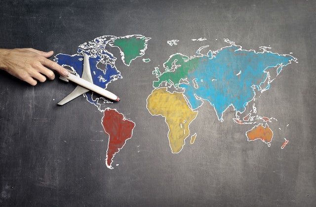 The map of the world drawn on a blackboard and a model of a plane