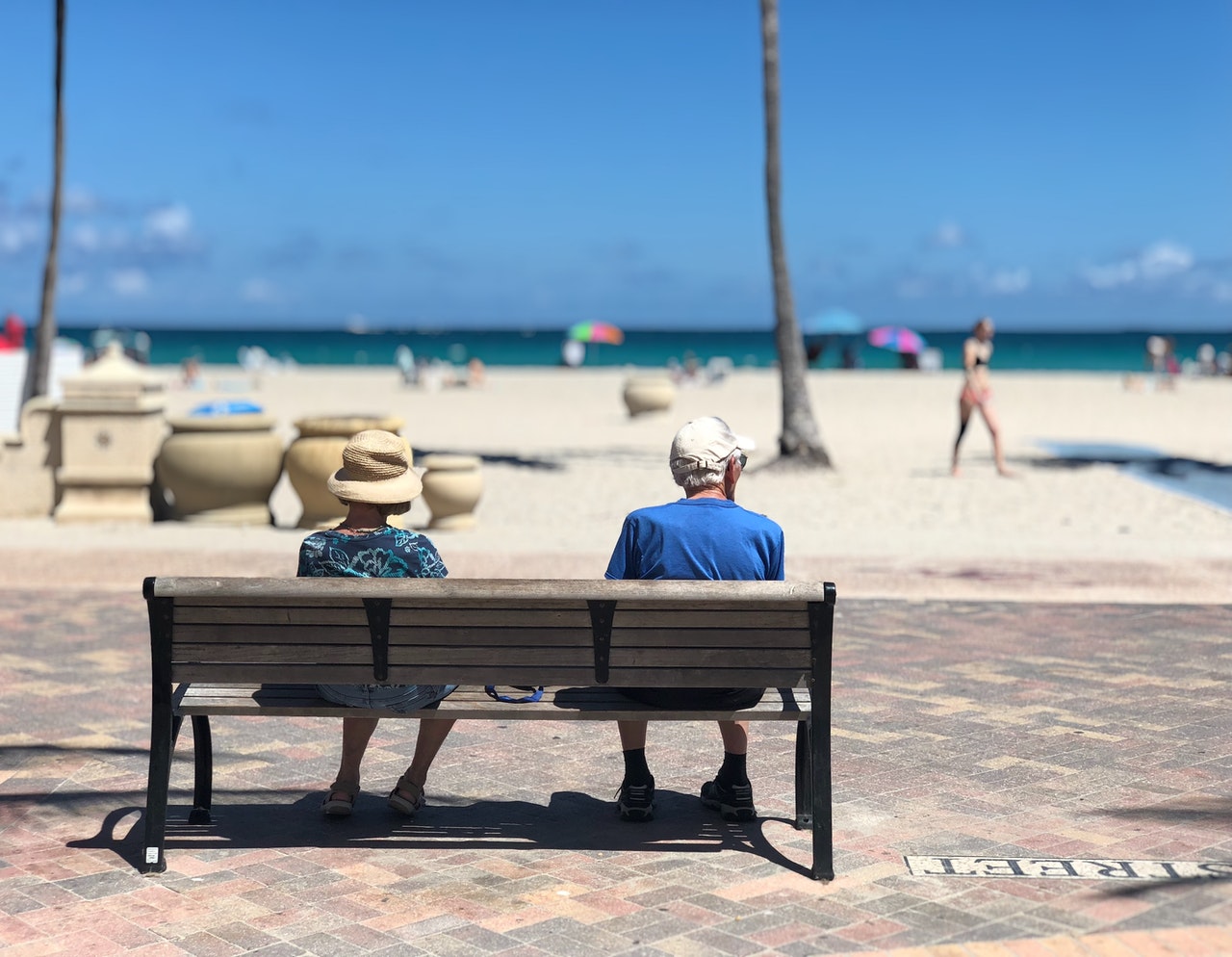 A senior couple sitting on a bench near a Florida beach