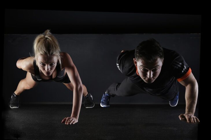 A woman and a man doing push-ups